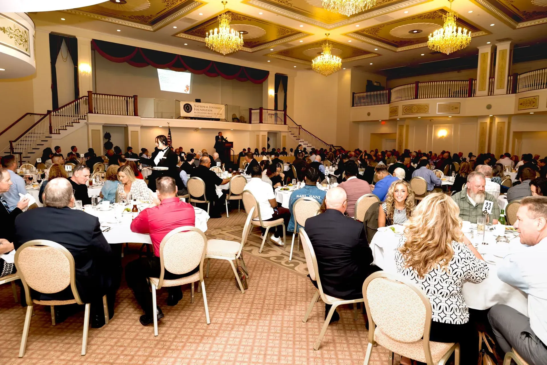 a large group of people are sitting at tables in a large room