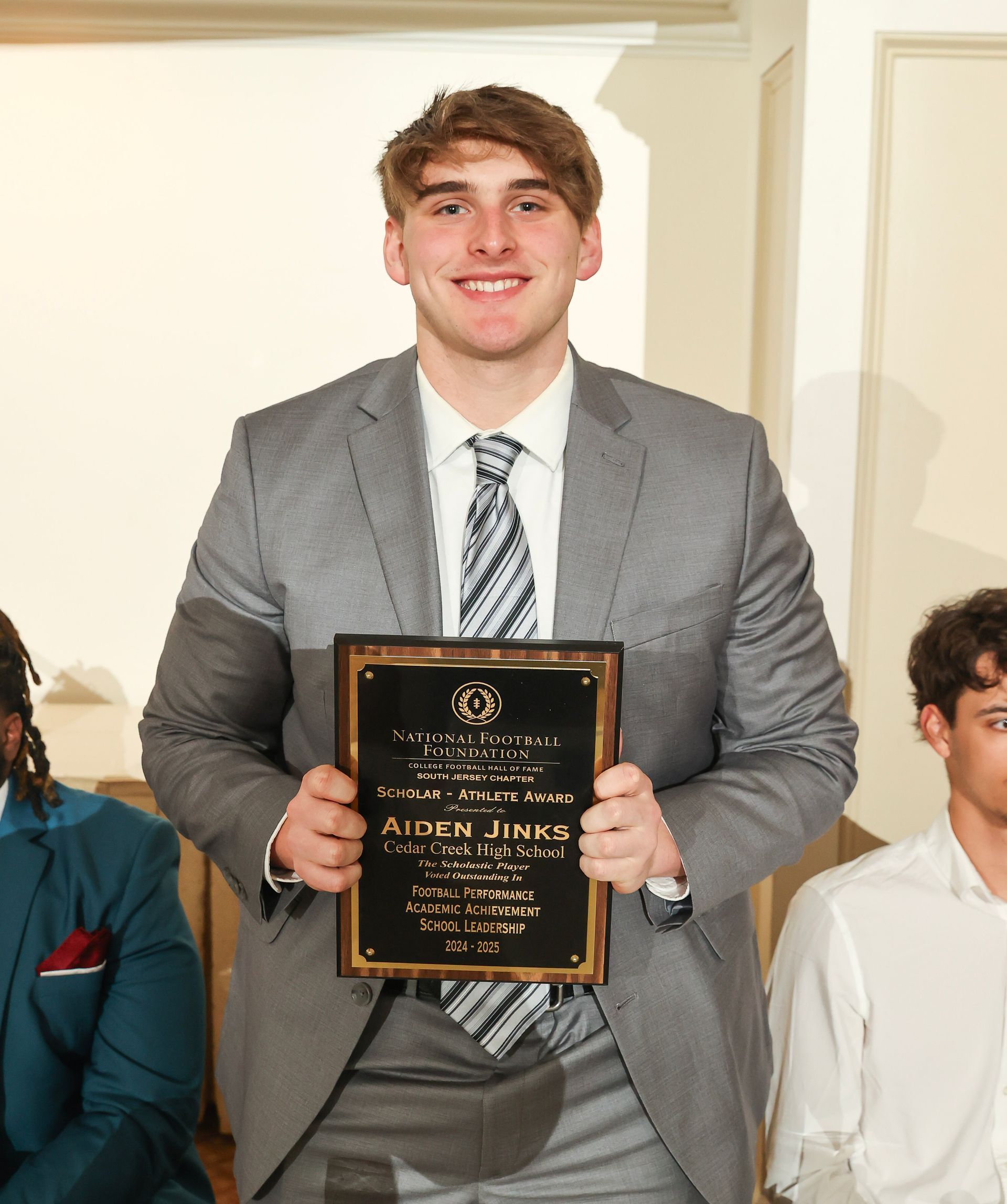 aiden jinks of cedar creek high school holding an awards plaque