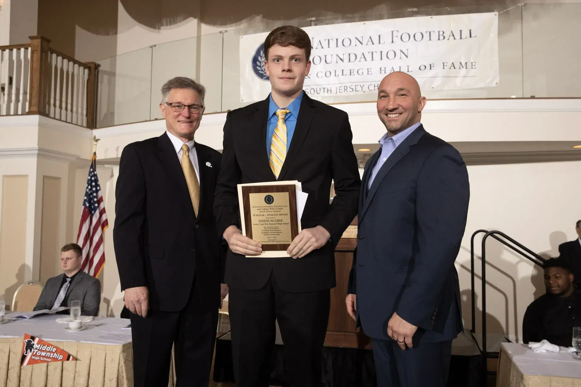 a man in a suit and tie is holding a plaque