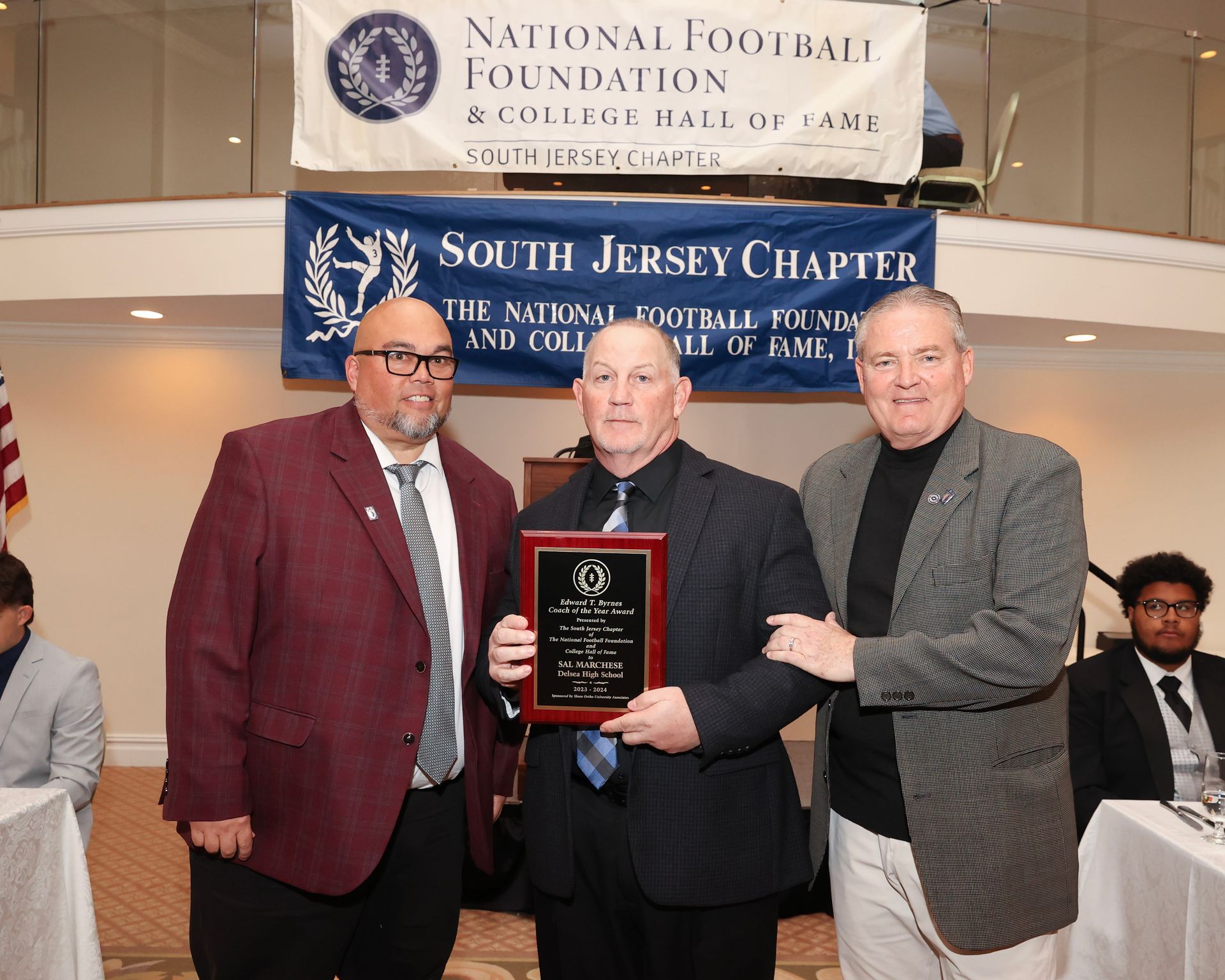 Three men are standing in front of a banner that says south jersey chapter