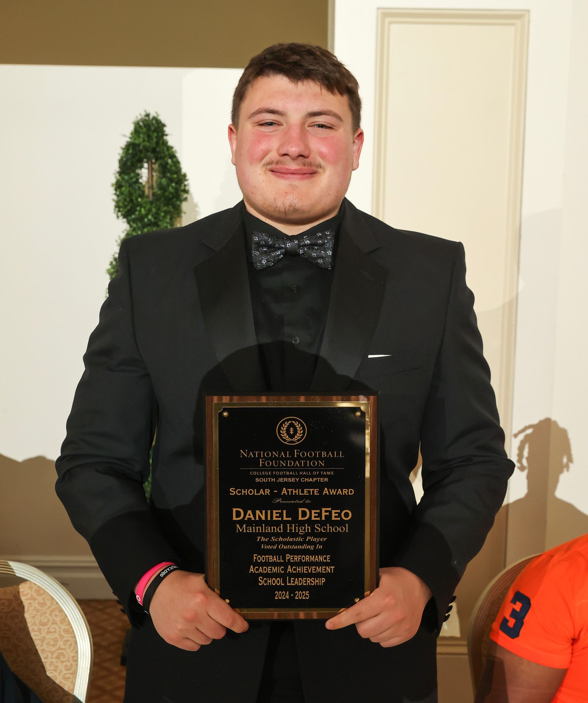 daniel defeo of mainland regional high school holding an awards plaque
