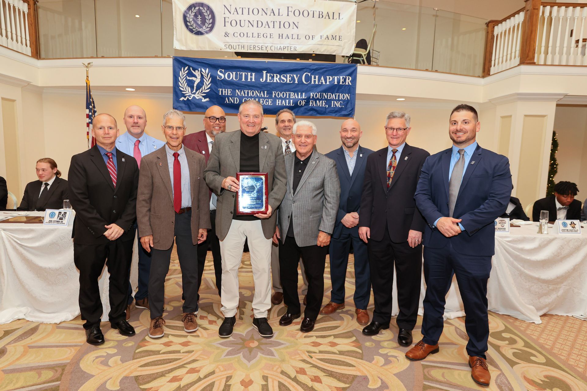 A group of men in suits and ties are posing for a picture