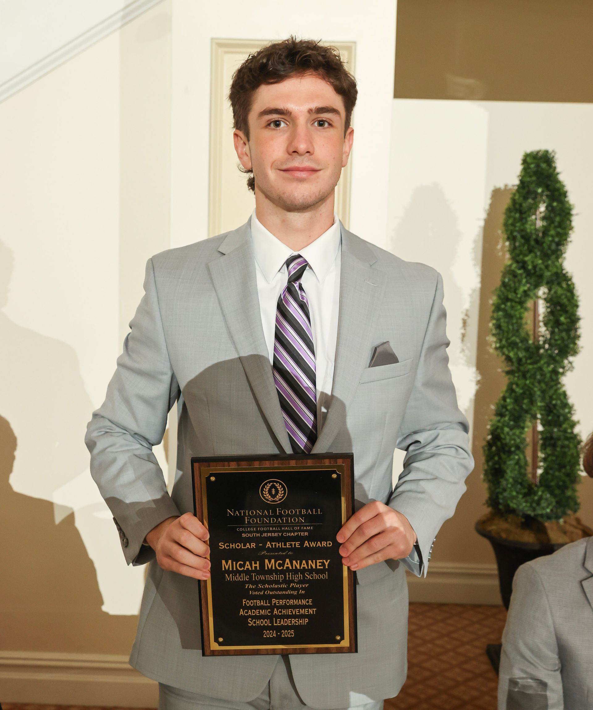 micah mcananey of middle township high school holding an awards plaque