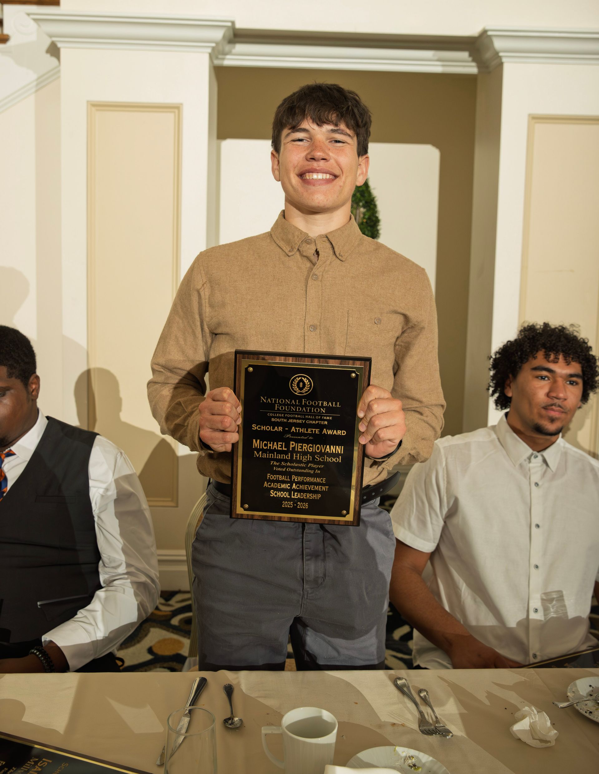 Michael Piergiovanni from Mainland Regional High School holding scholar-athlete awards plaque from NFFSJ