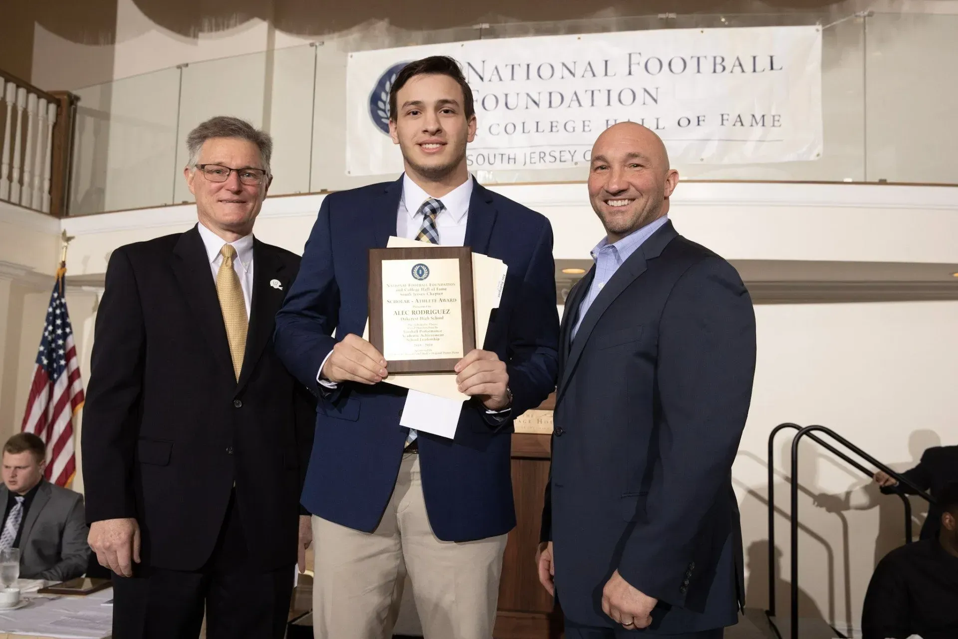 a man in a blue jacket is holding a certificate