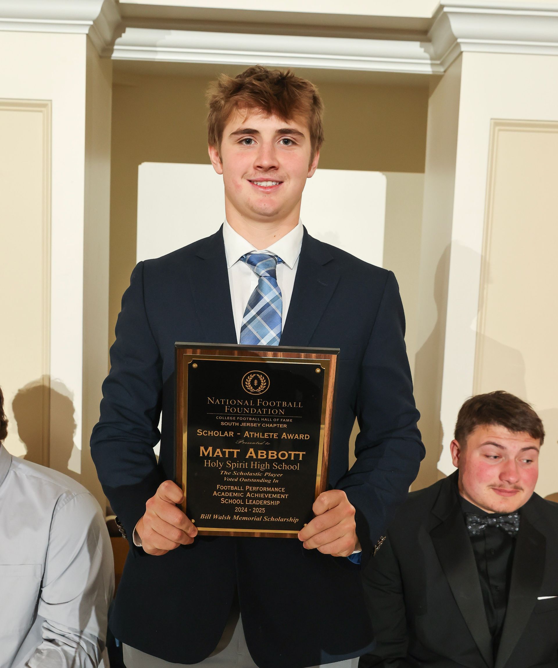 matt abbott of holy spirit high school holding an awards plaque