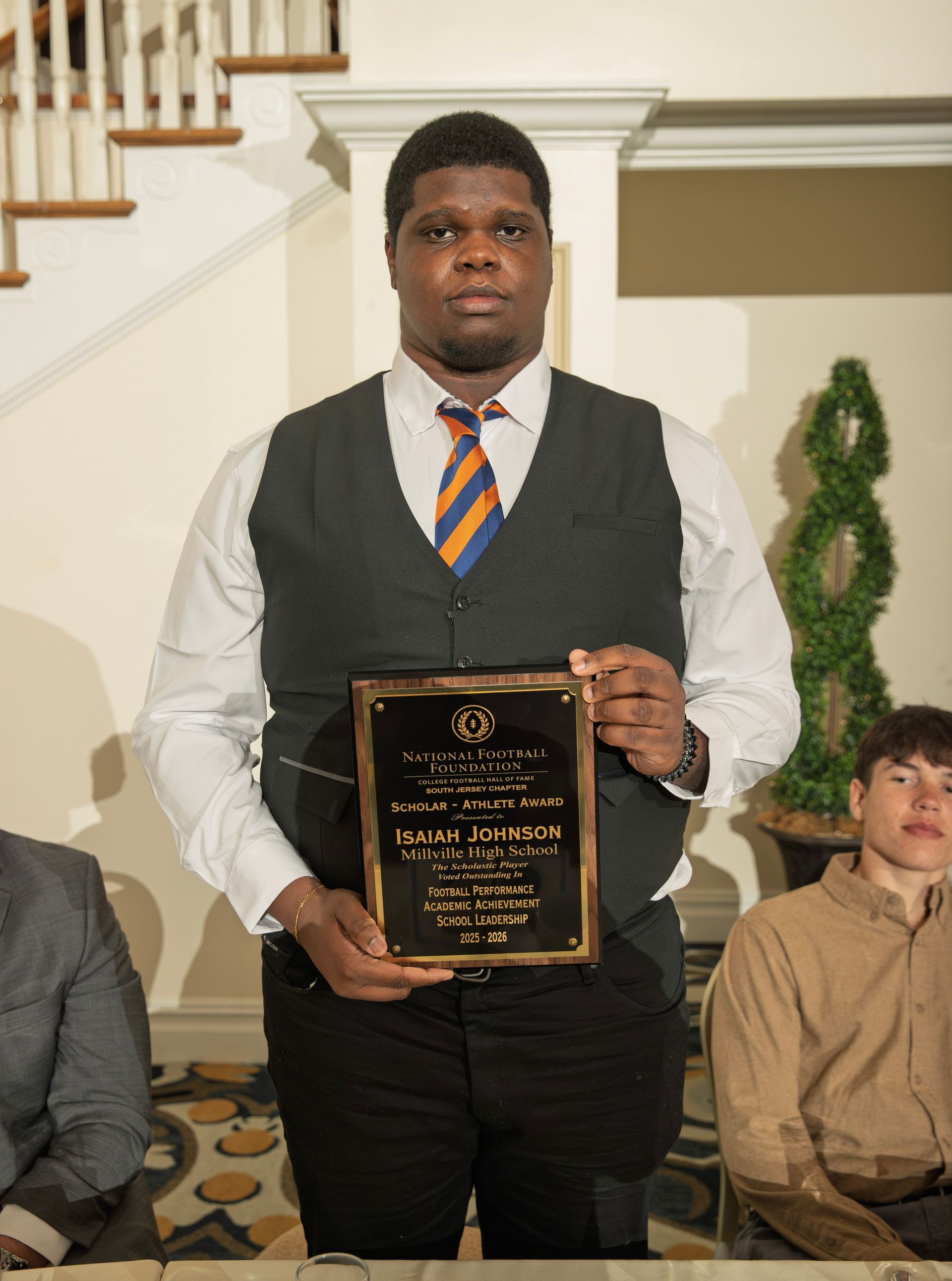Isaiah Johnson from Millville Senior High School holding scholar-athlete awards plaque from NFFSJ