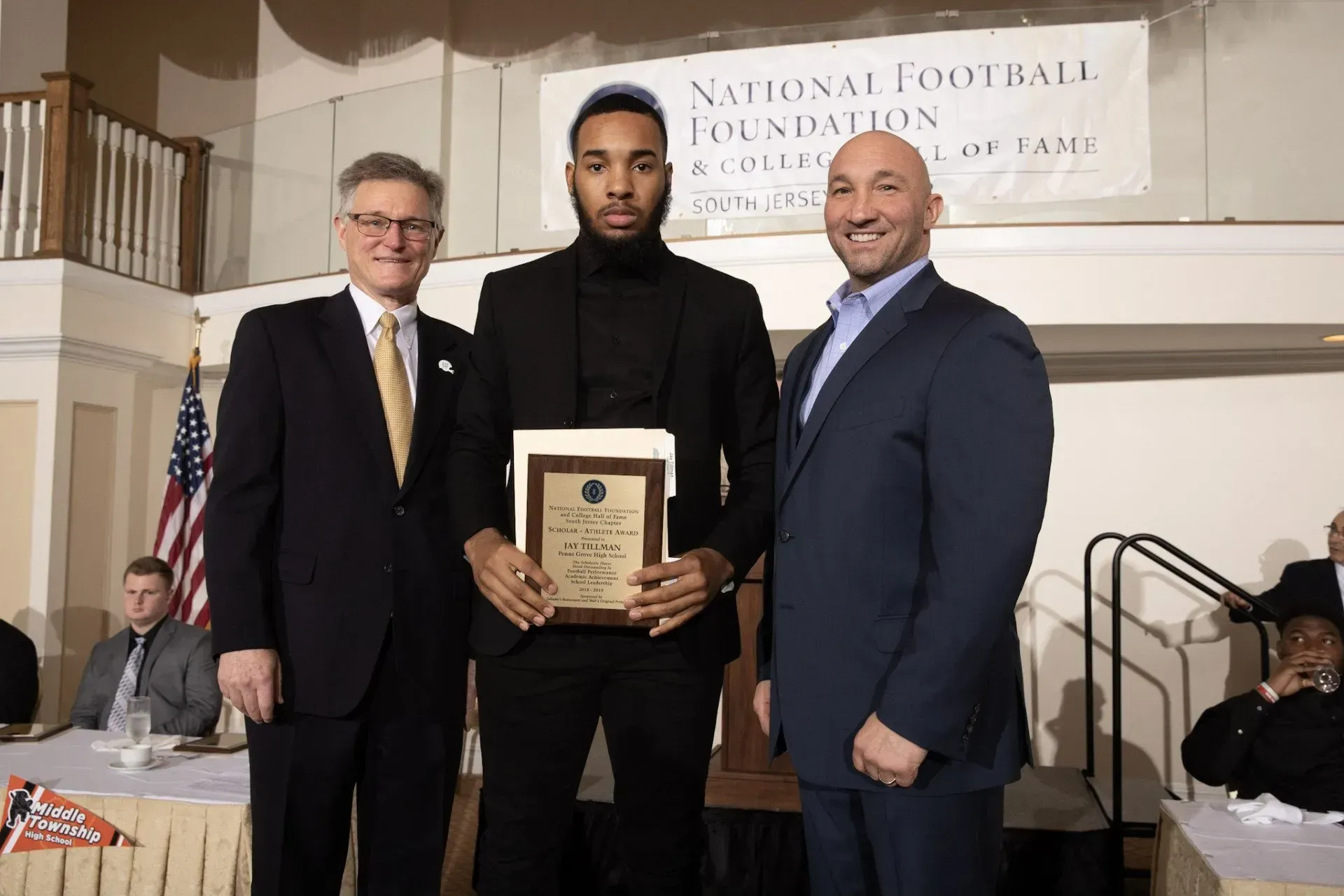three men standing in front of a sign that says national football foundation