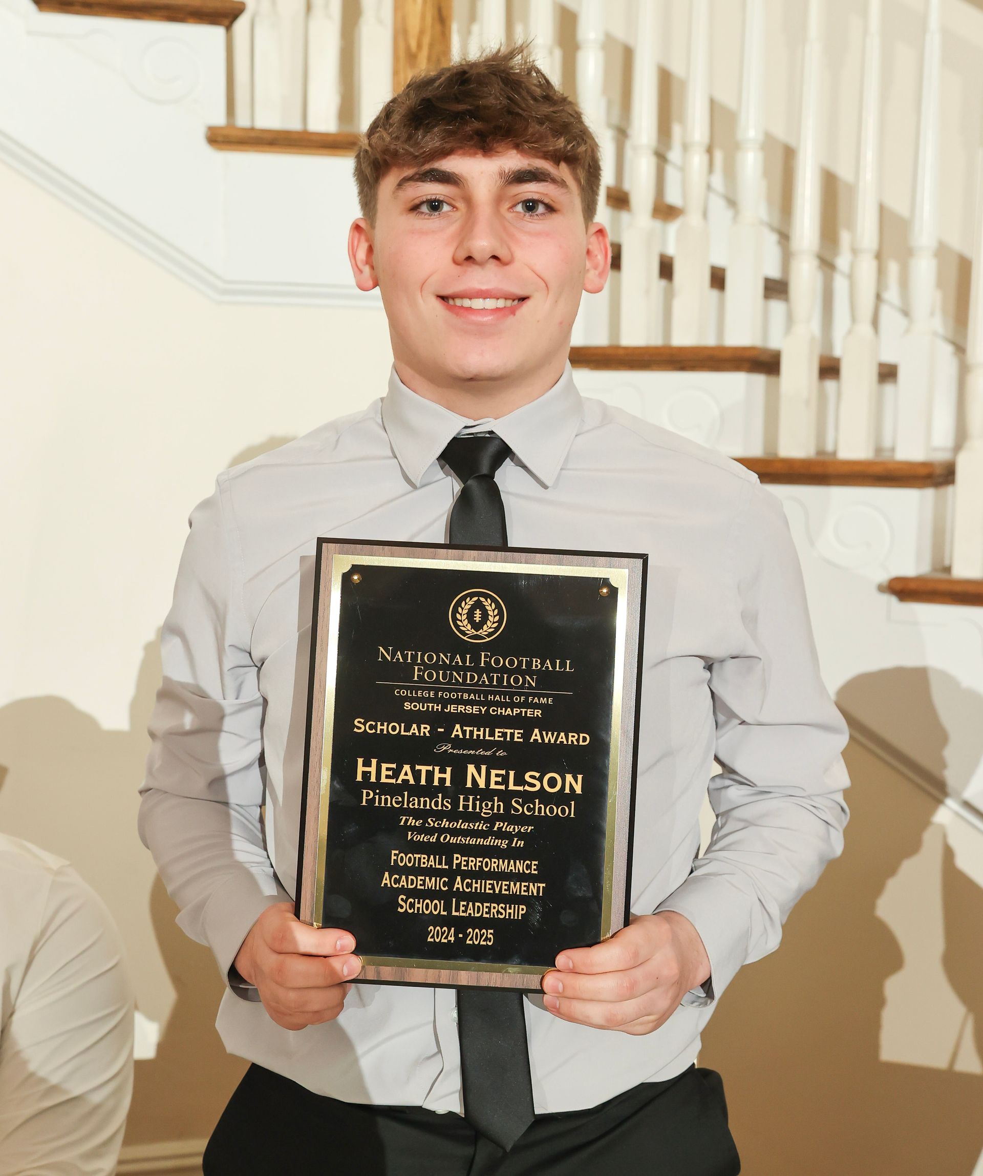 heath nelson of pinelands high school holding an awards plaque