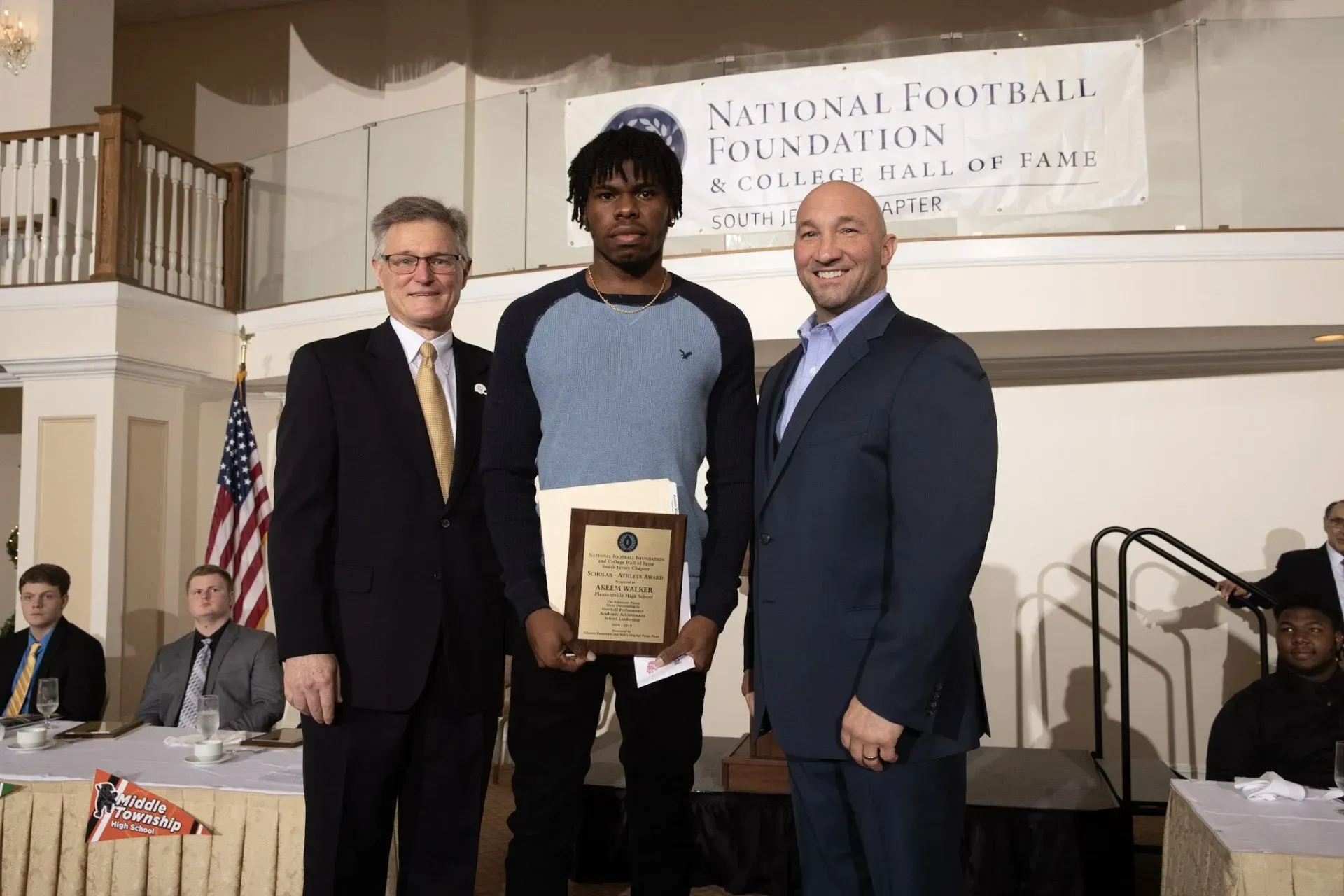 three men standing in front of a national foundation banner