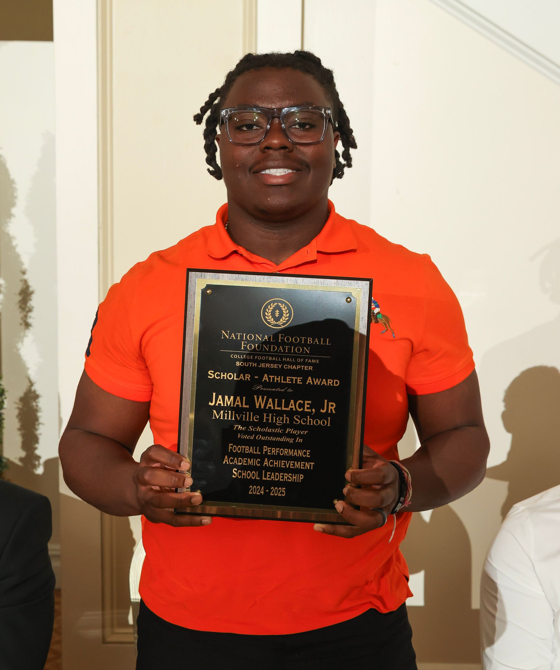 jamal wallace jr. of millville high school holding an awards plaque