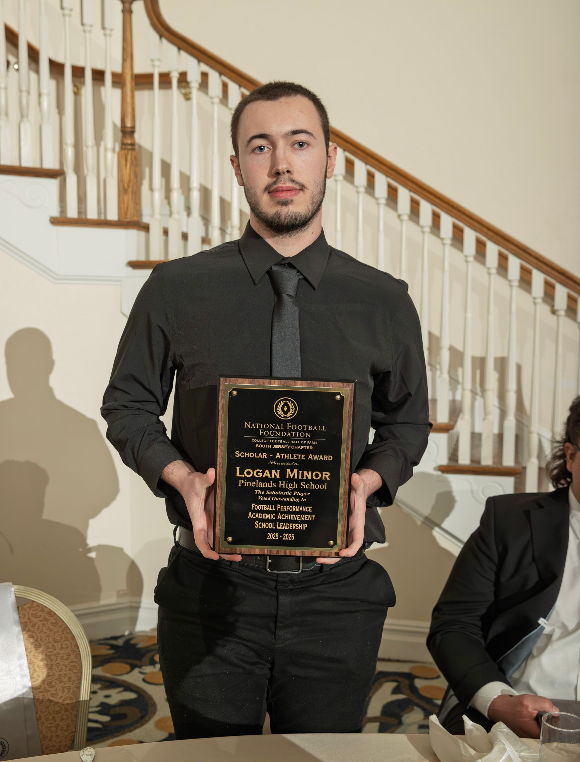 Logan Minor from Pinelands Regional High School holding scholar-athlete awards plaque from NFFSJ