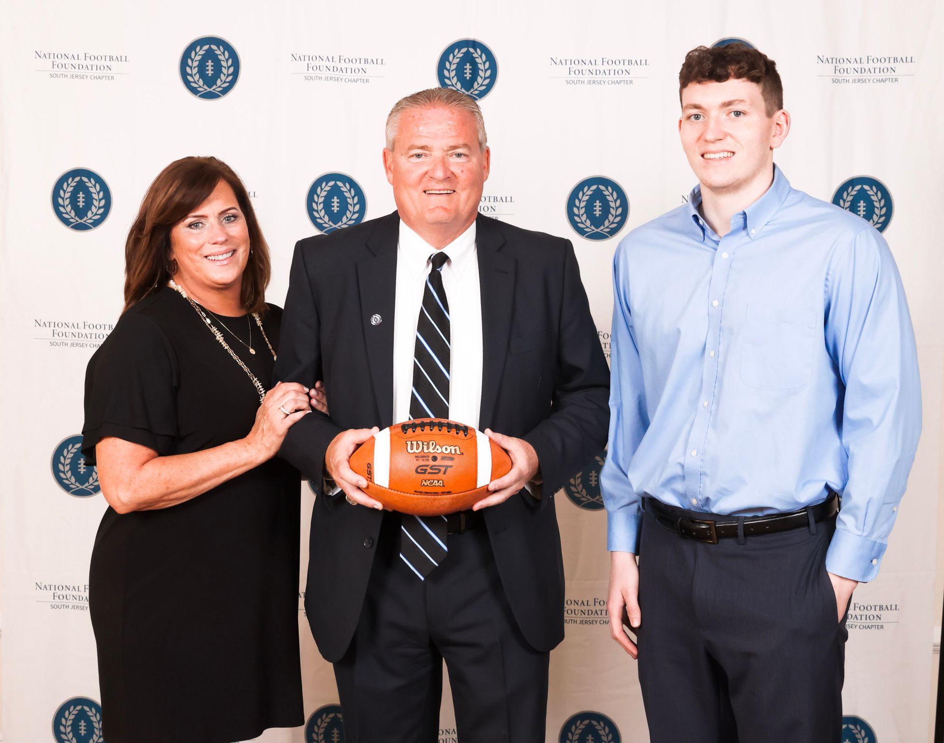 a man in a suit and tie is holding a football