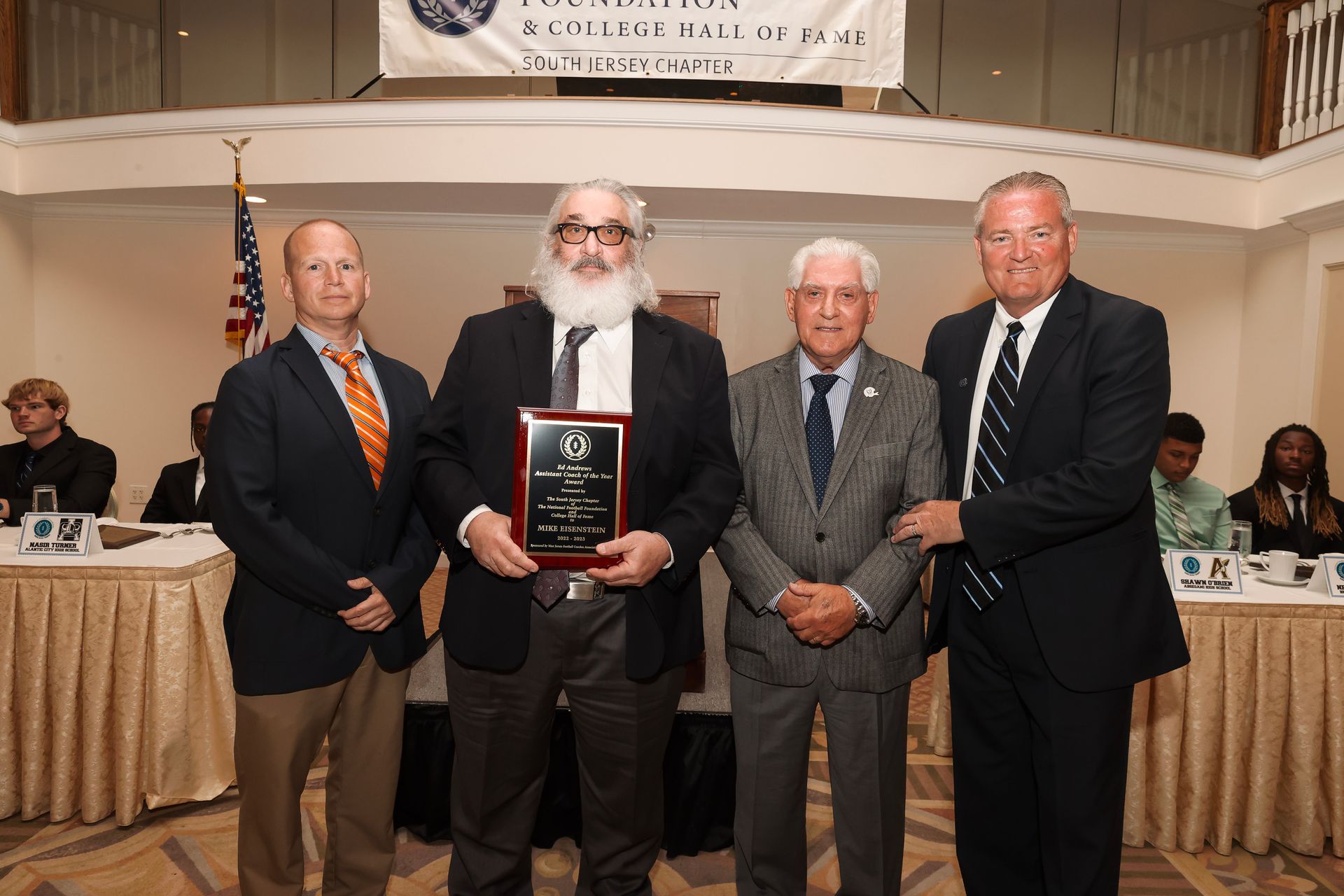 a man in a suit and tie is holding a plaque
