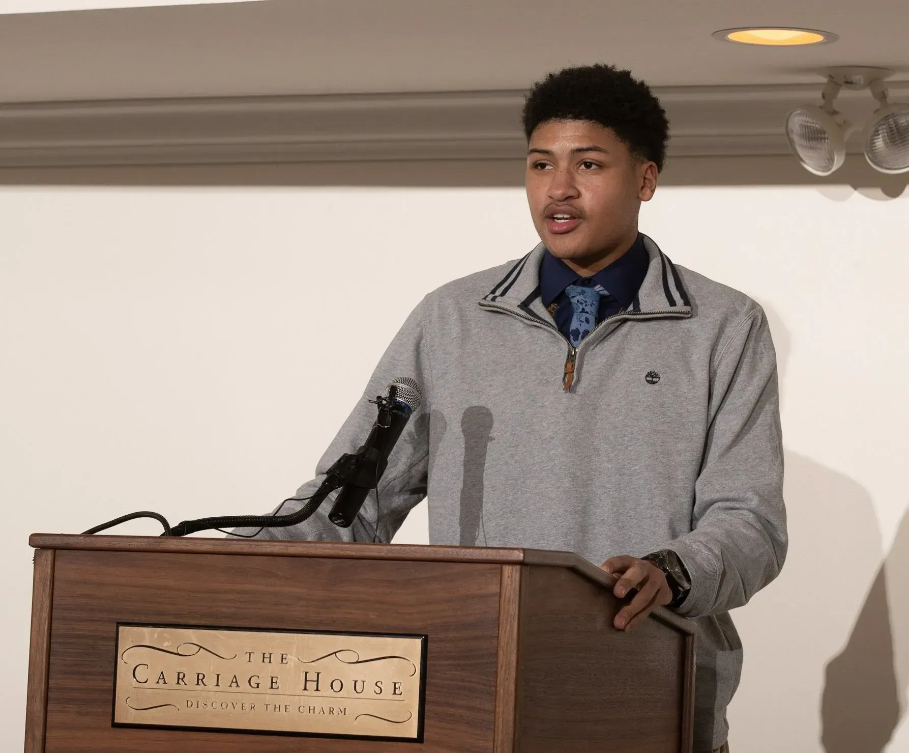 a man stands at a podium with a sign that says ' george jones ' on it