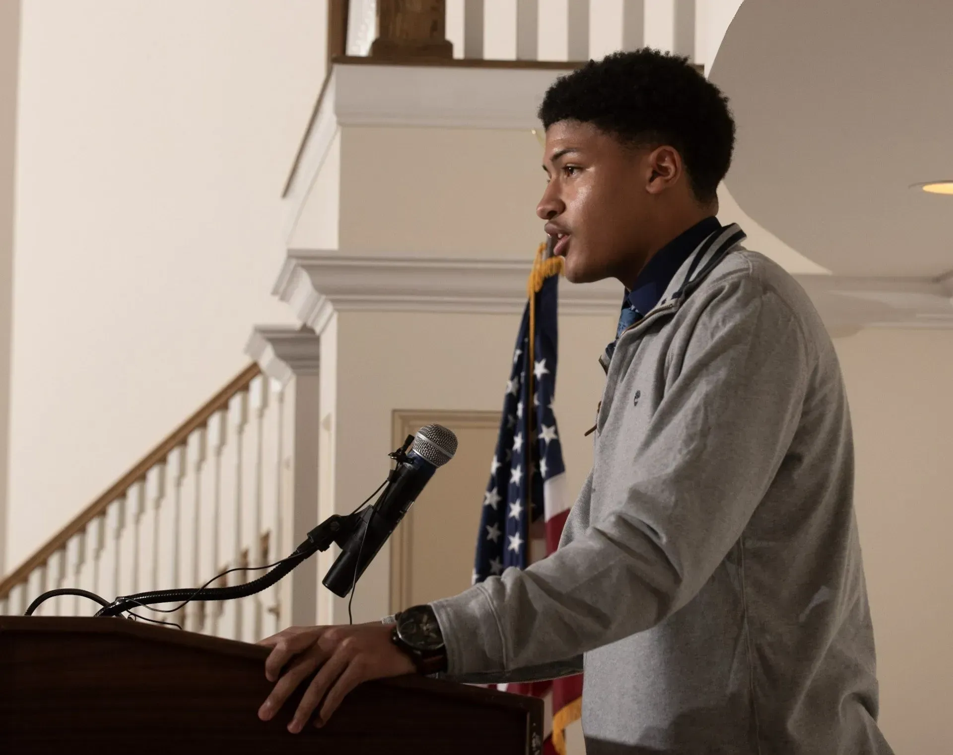 a man stands at a podium speaking into a microphone