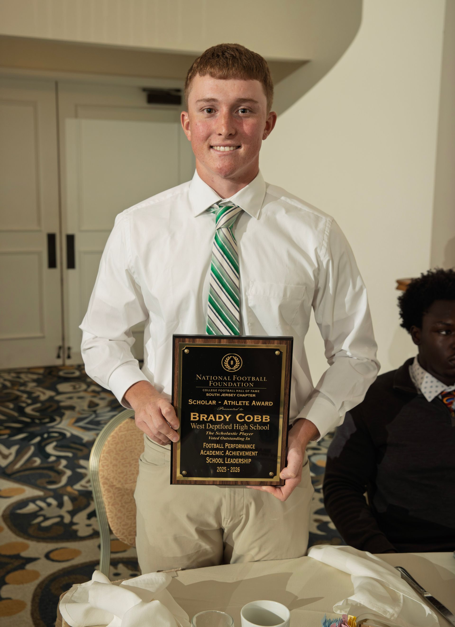 Brady Cobb from West Deptford High School holding scholar-athlete awards plaque from NFFSJ