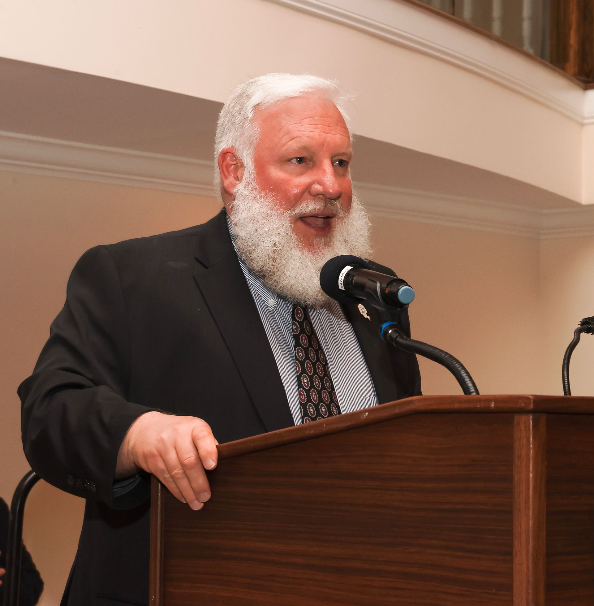 a man with a beard is speaking into a microphone