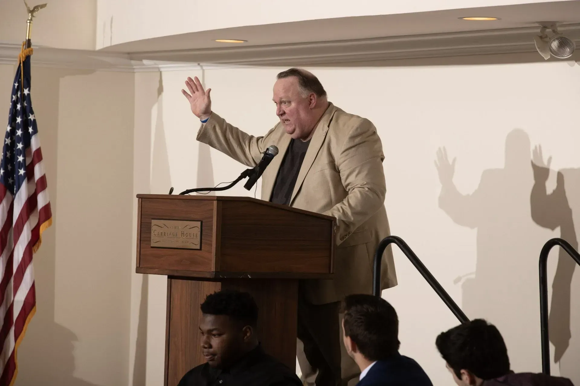 a man stands at a podium speaking into a microphone