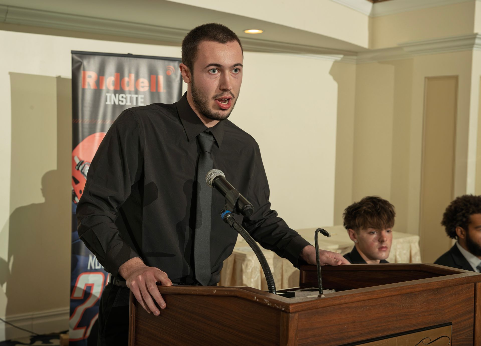 Logan Minor giving speech at the podium during the 2028 South Jersey NFF awards banquet