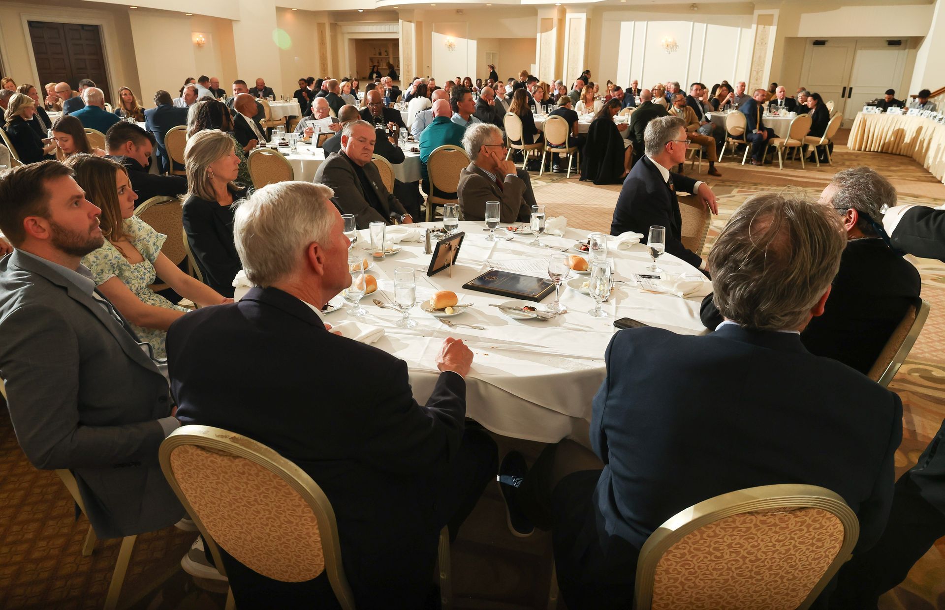 A large group of people are sitting at tables in a large room