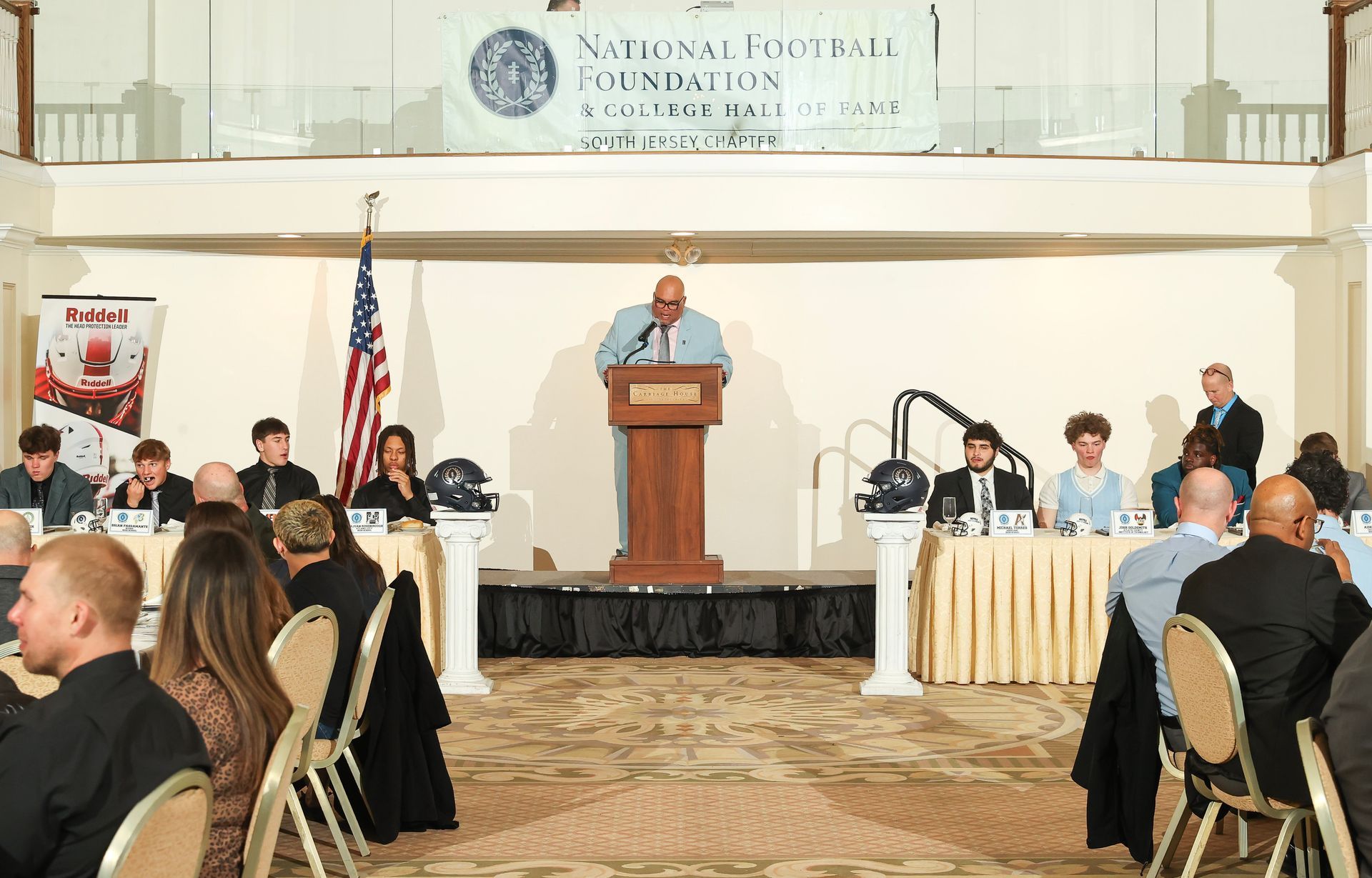 A man is giving a speech at a south jersey chapter of the national football foundation awards banquet