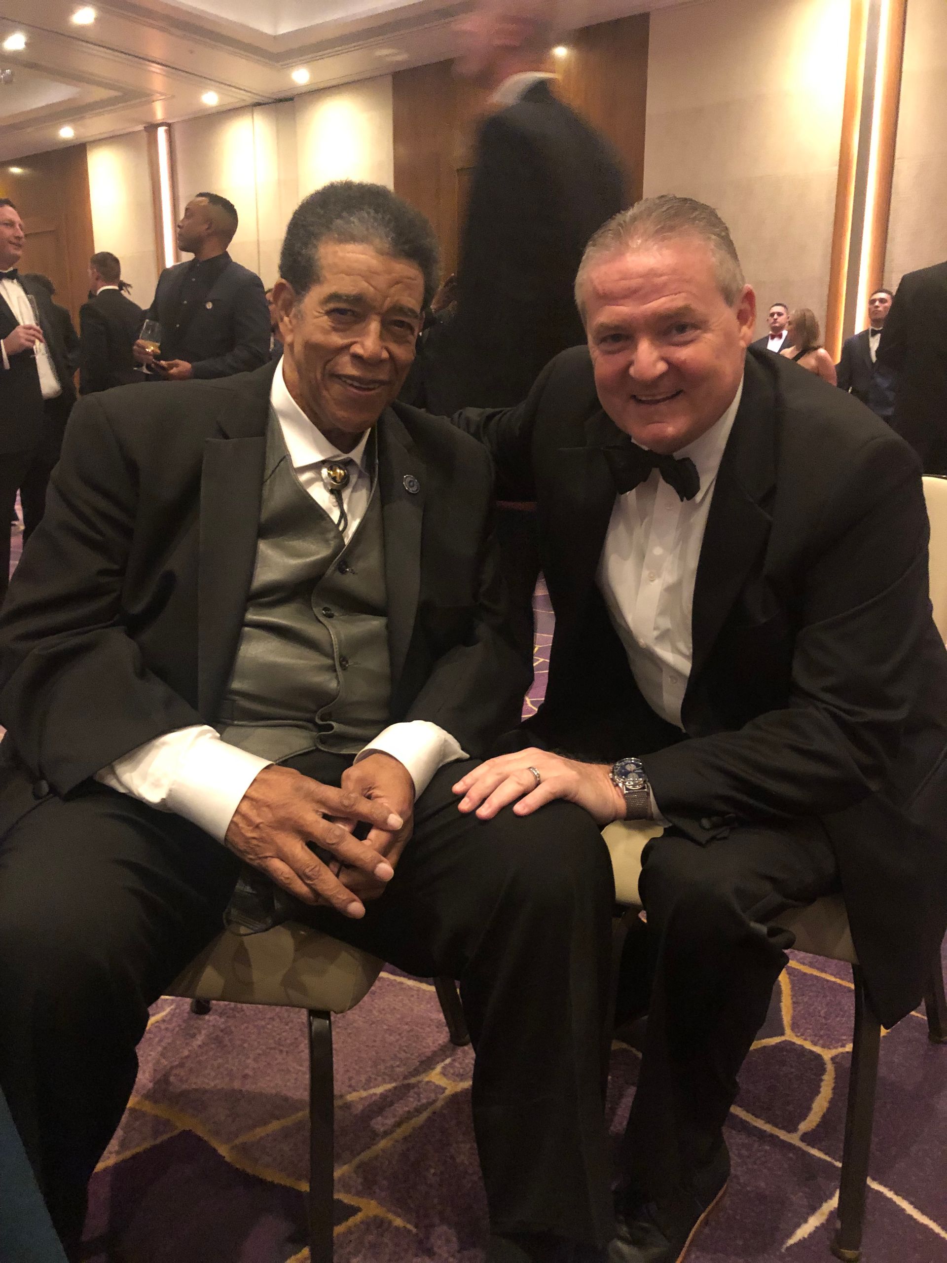 michael gatley president of NFFSJ sitting with another man at 63 Annual National Football Foundation Awards Dinner