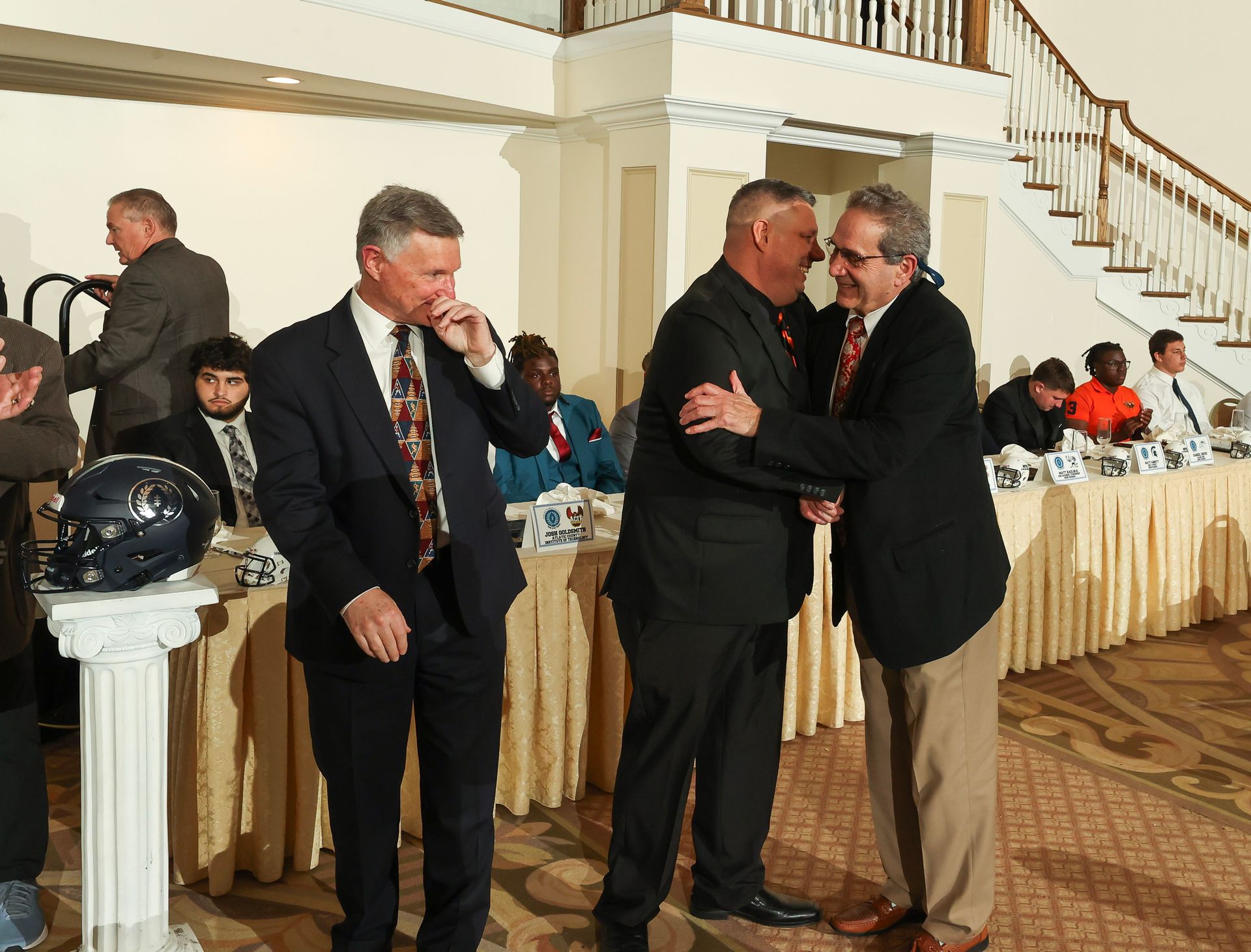 A group of men in suits and ties are standing in a room