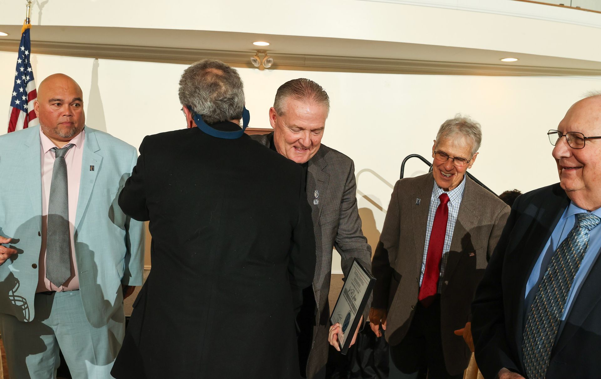 A group of men in suits and ties are shaking hands