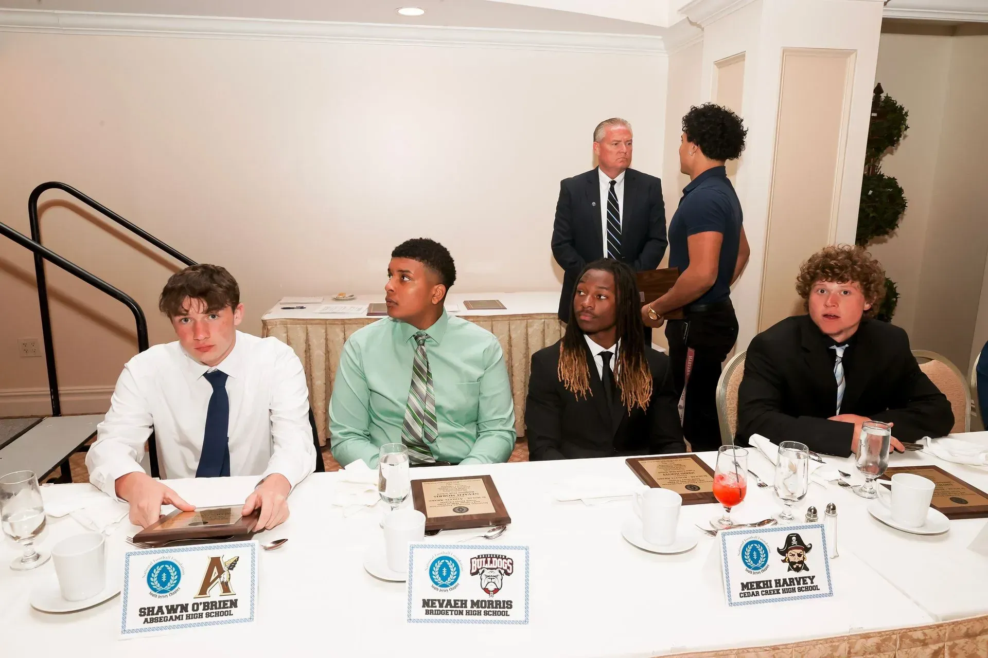 a group of people sitting at a table with a sign that says ok on it