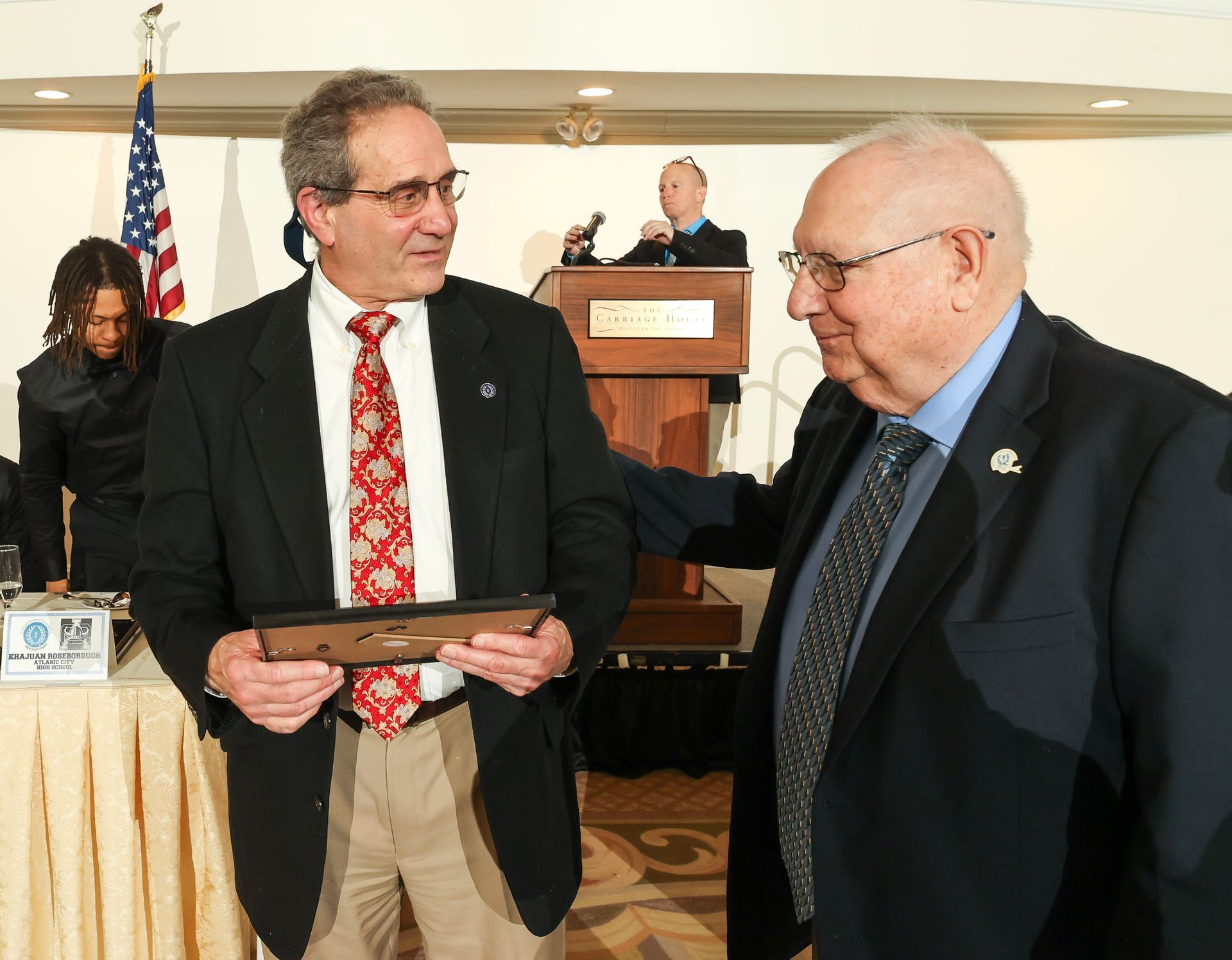 Two men in suits and ties are standing next to each other