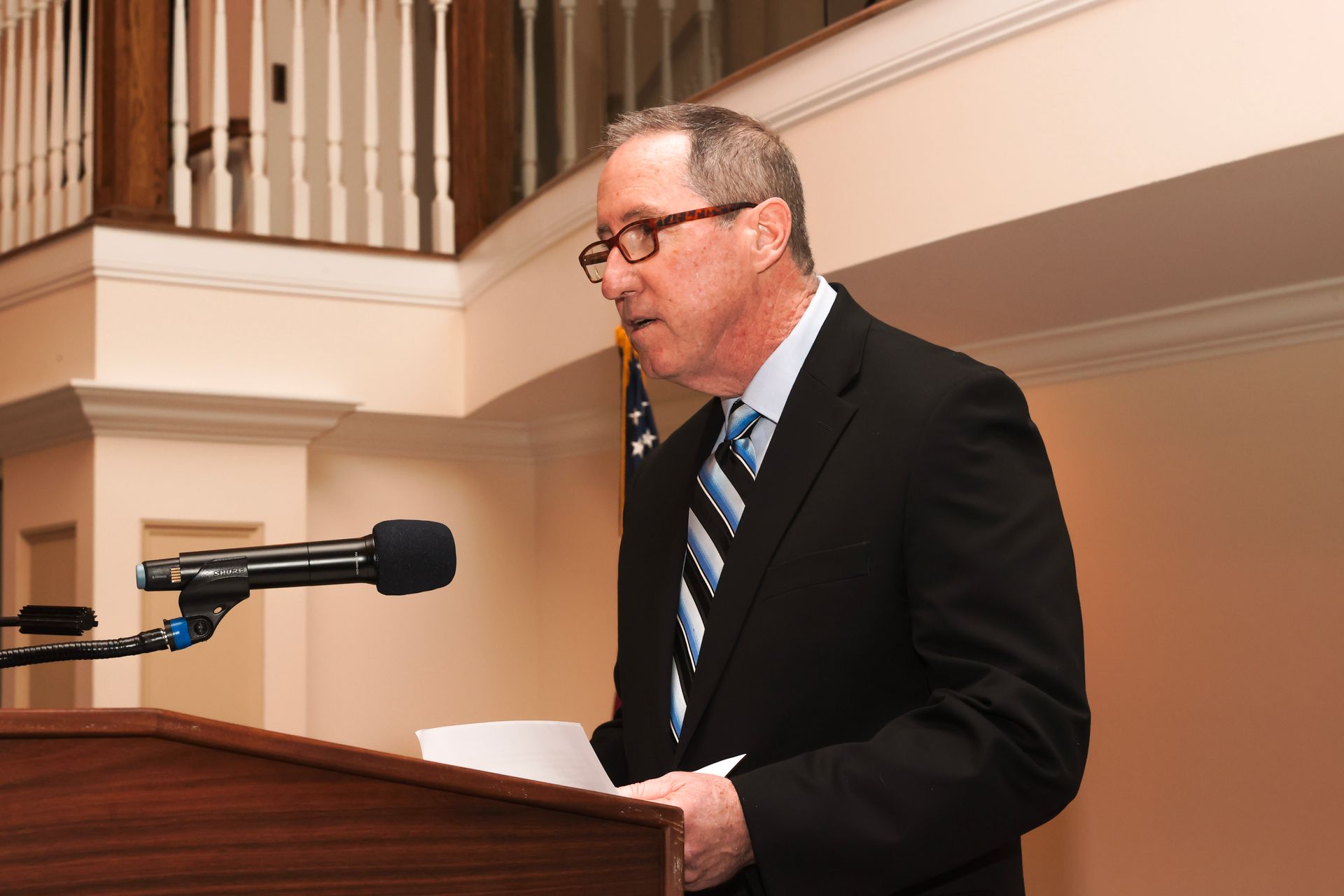 a man in a suit and tie is speaking into a microphone