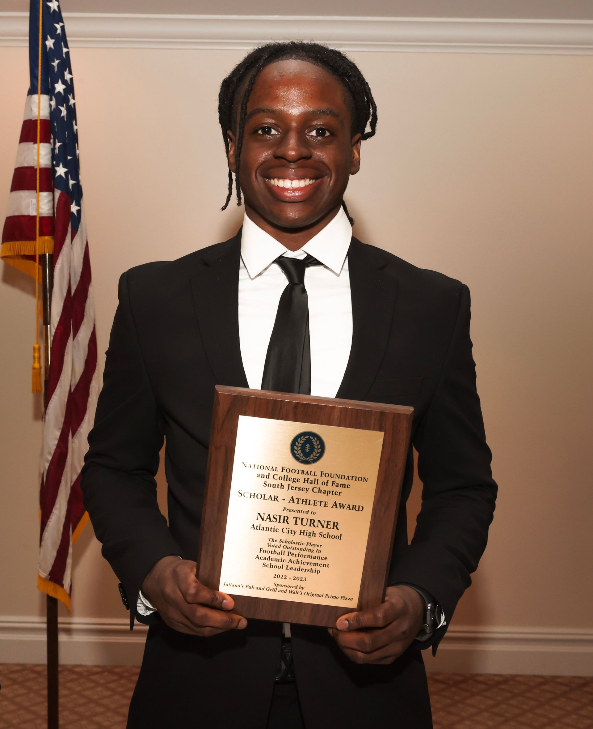 a man in a suit and tie is holding a plaque