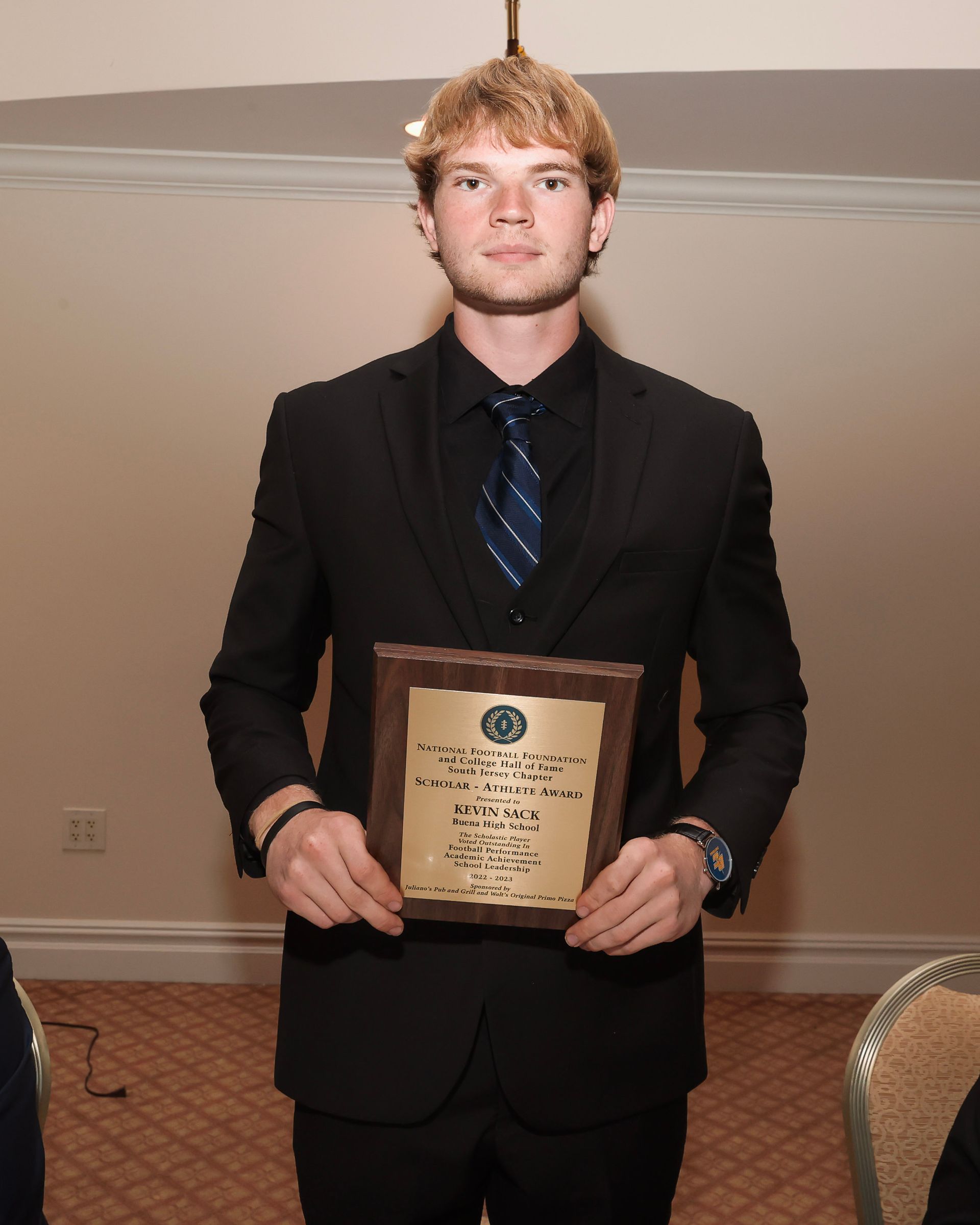 a man in a suit and tie is holding a plaque