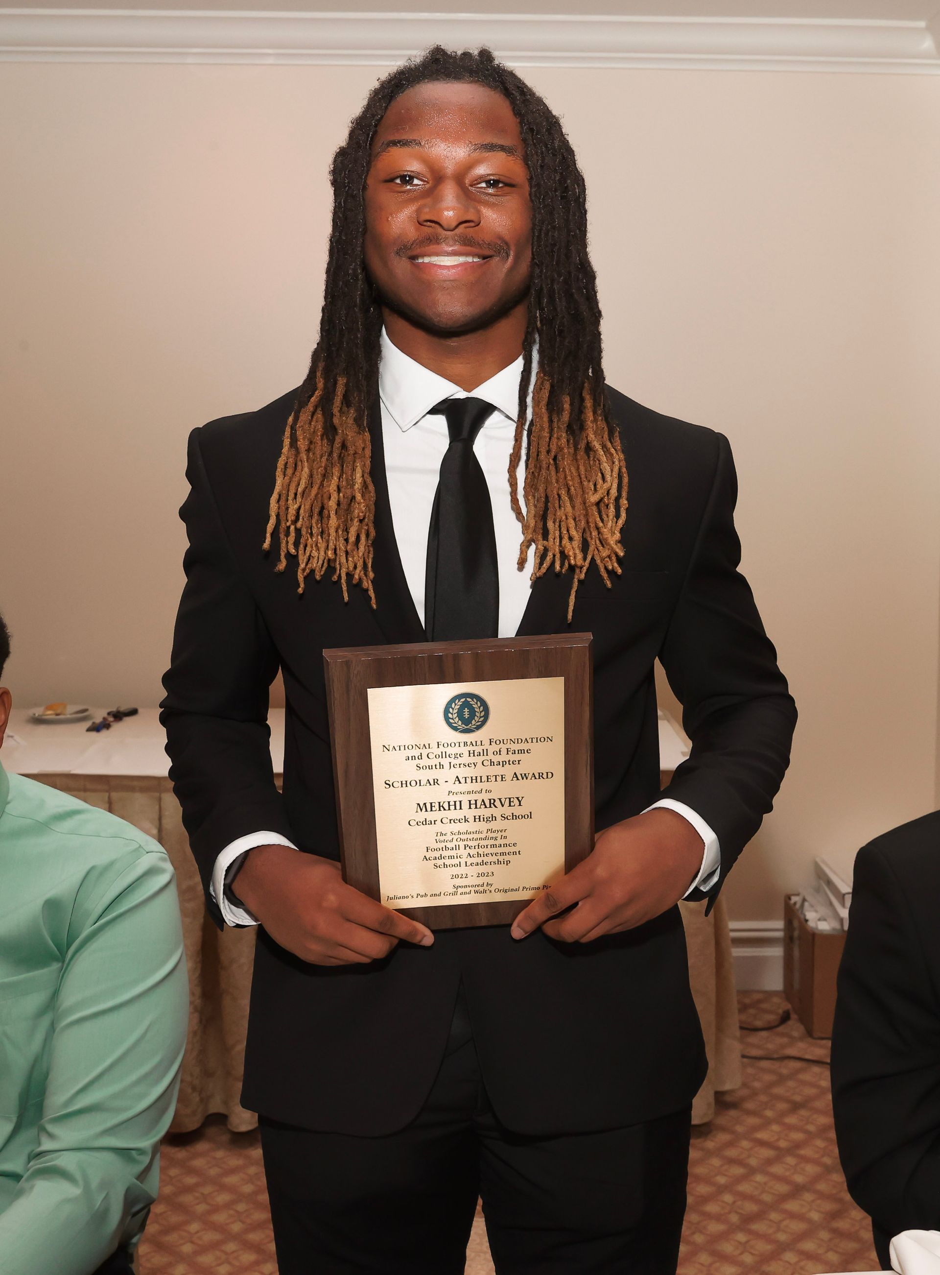 a man in a suit and tie is holding a plaque