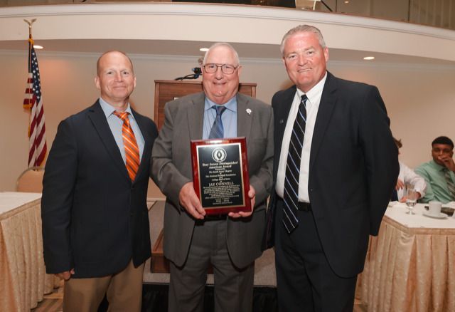 a man in a suit and tie is holding a plaque
