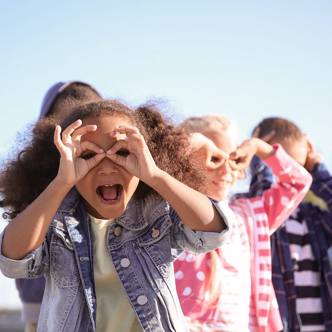 Children pretending to make eye glasses with their fingers