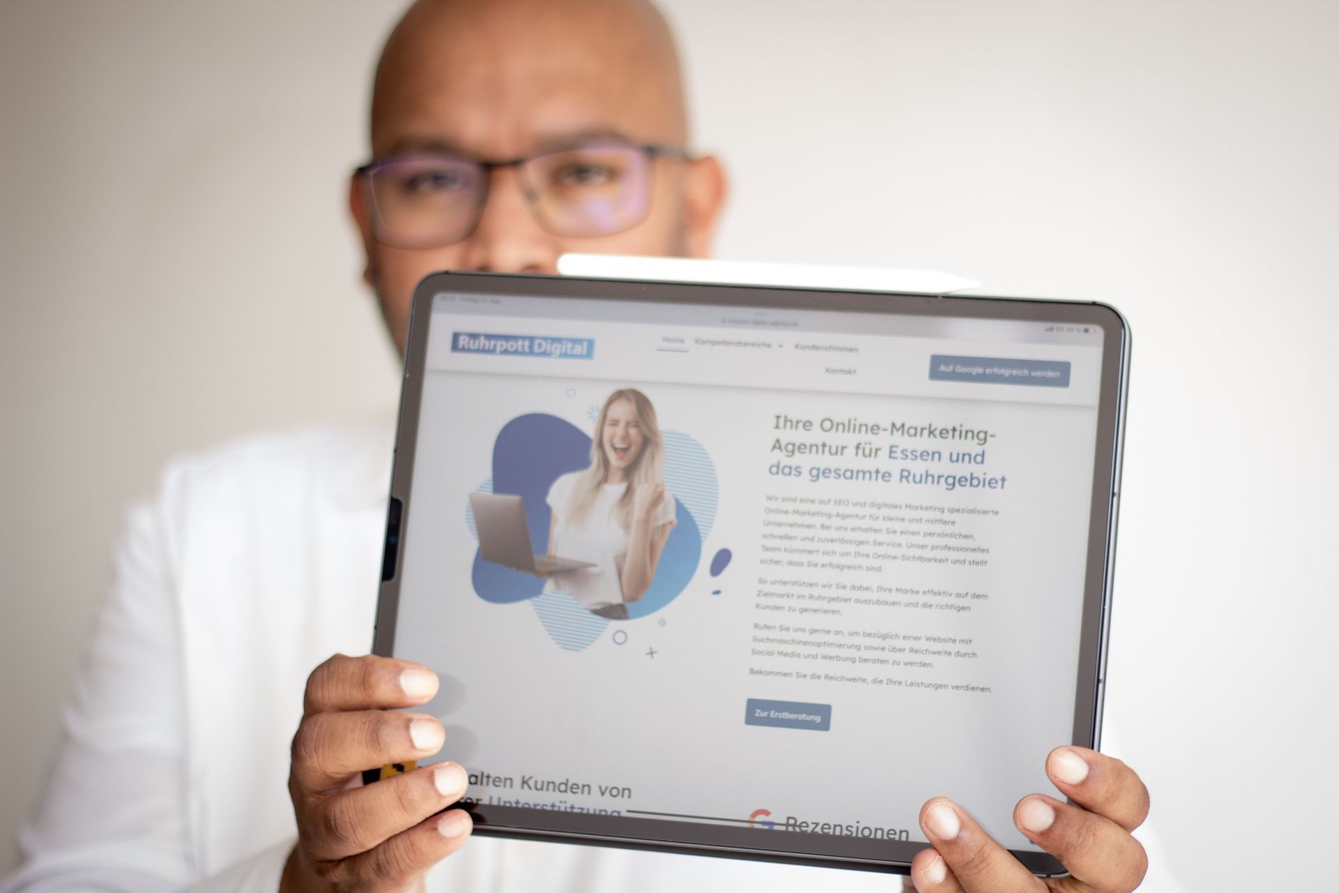 Zwei Männer, einer in einem roten, der andere in einem cremefarbenen Pullover, zeigen den Daumen nach oben. 