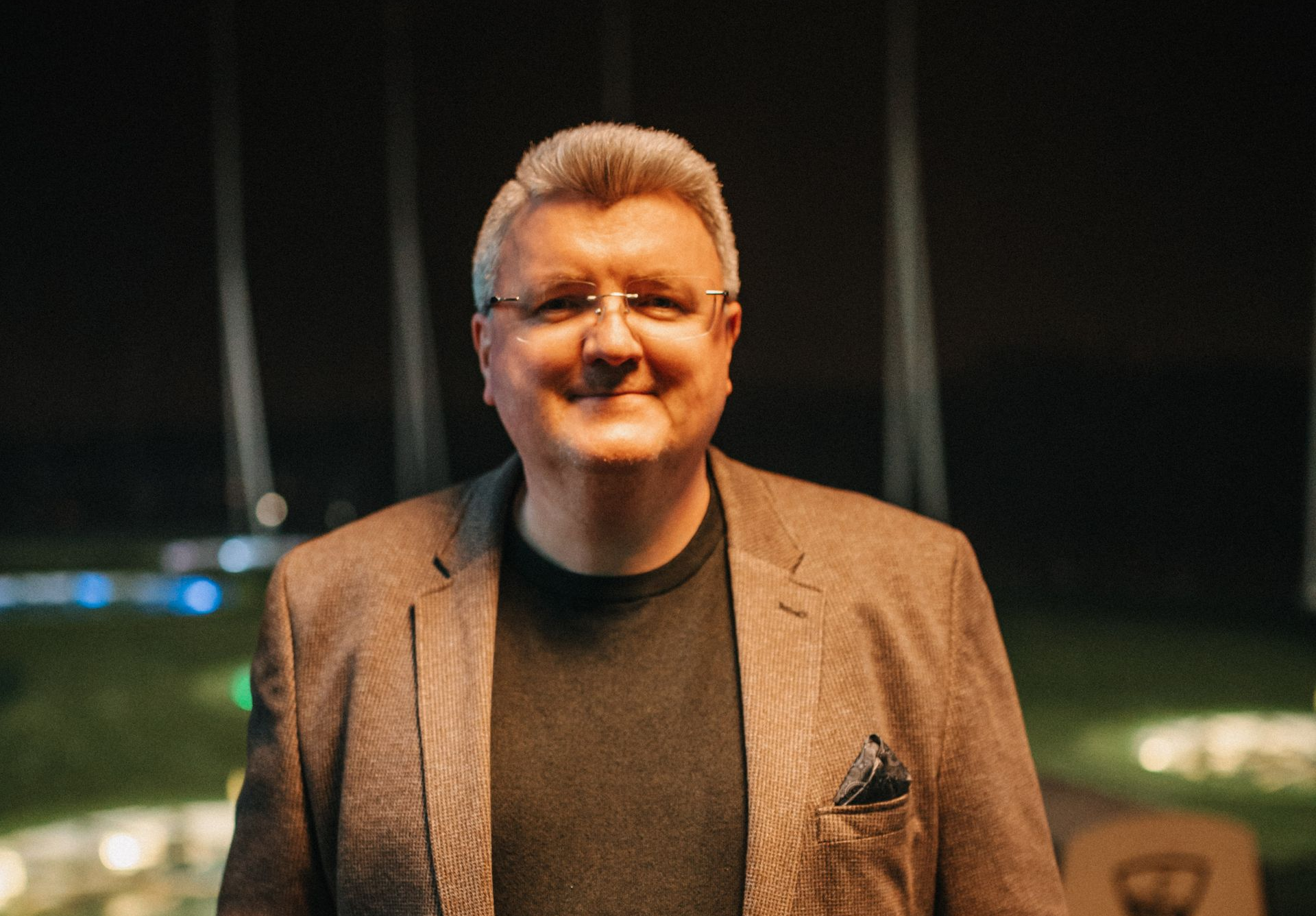 Eine Person, die nachts mit einem Golfschläger spielt, eine Weihnachtsmannmütze trägt und auf einer grünen Matte steht.