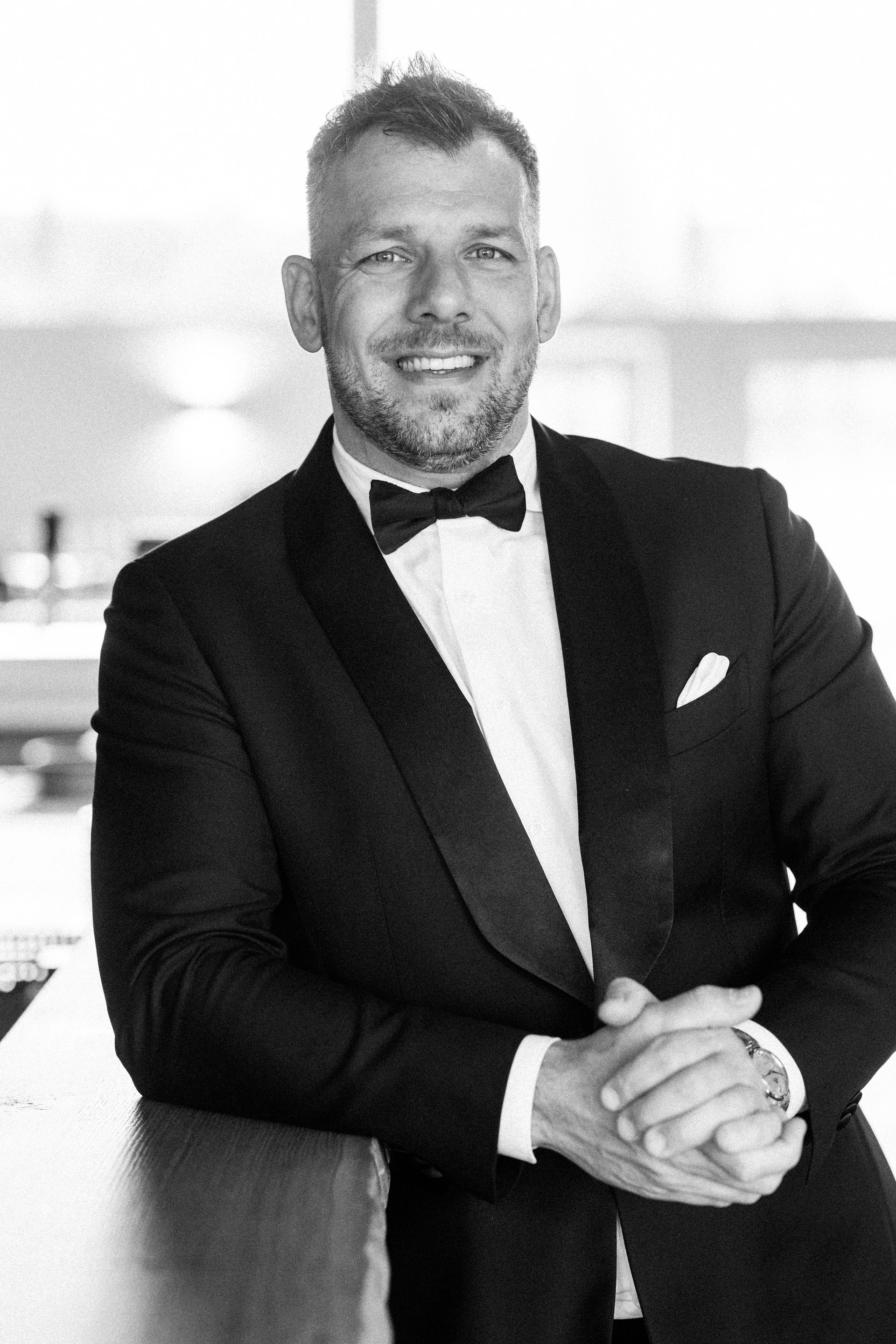 Zwei Männer, einer in einem roten, der andere in einem cremefarbenen Pullover, zeigen den Daumen nach oben. 