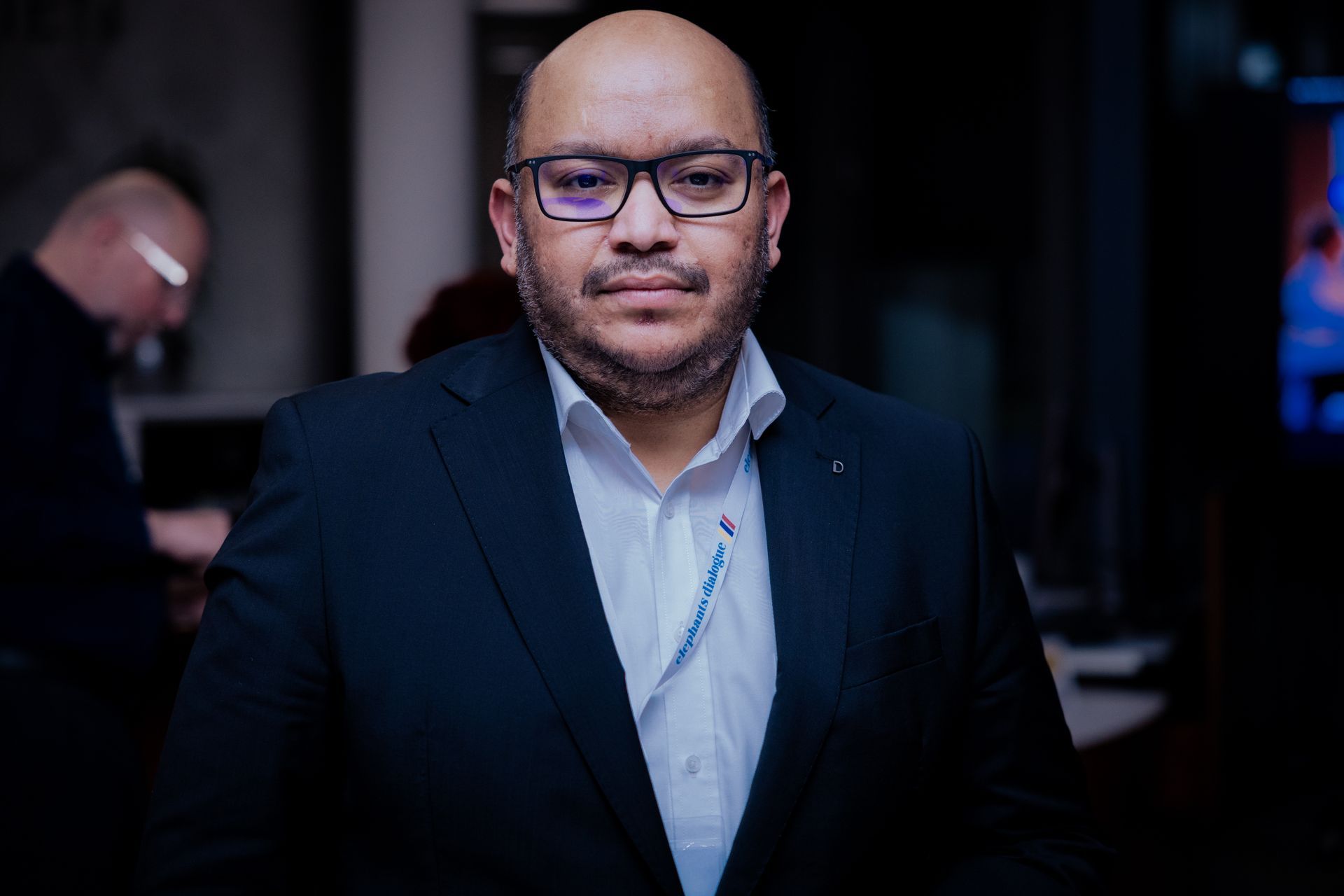 Eine Person, die nachts mit einem Golfschläger spielt, eine Weihnachtsmannmütze trägt und auf einer grünen Matte steht.