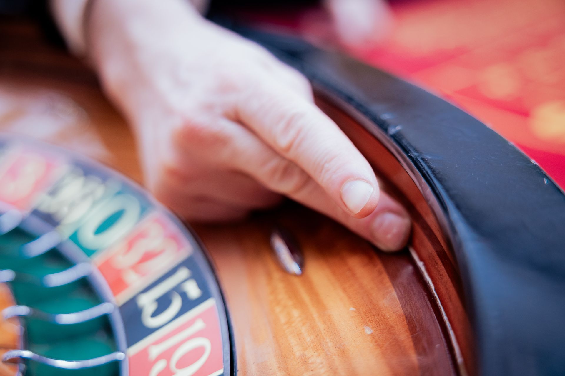 Drei Personen sitzen an einem Tisch, trinken und unterhalten sich, Weihnachtsmarktkulisse, rote Tischdecke.
