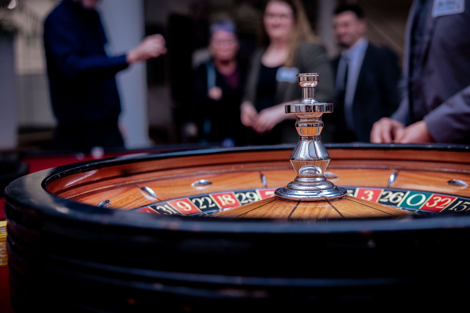 In einer Indoor-Golfanlage schauen sich Leute auf Bildschirmen Golf an. Einige tragen Weihnachtsmannmützen.