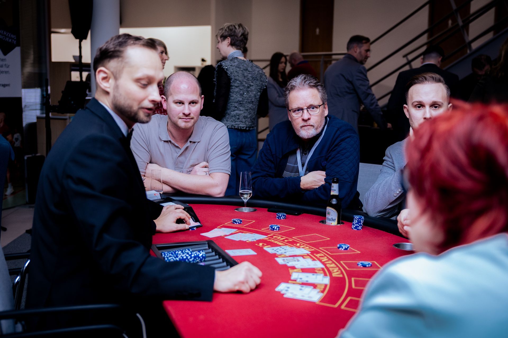 Zwei Männer, einer in einem roten, der andere in einem cremefarbenen Pullover, zeigen den Daumen nach oben. 