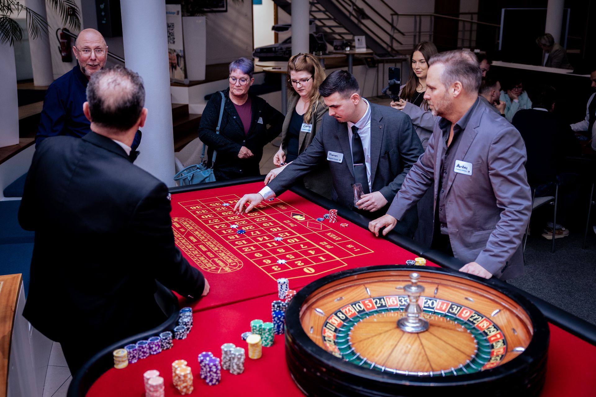 Eine Person, die nachts mit einem Golfschläger spielt, eine Weihnachtsmannmütze trägt und auf einer grünen Matte steht.