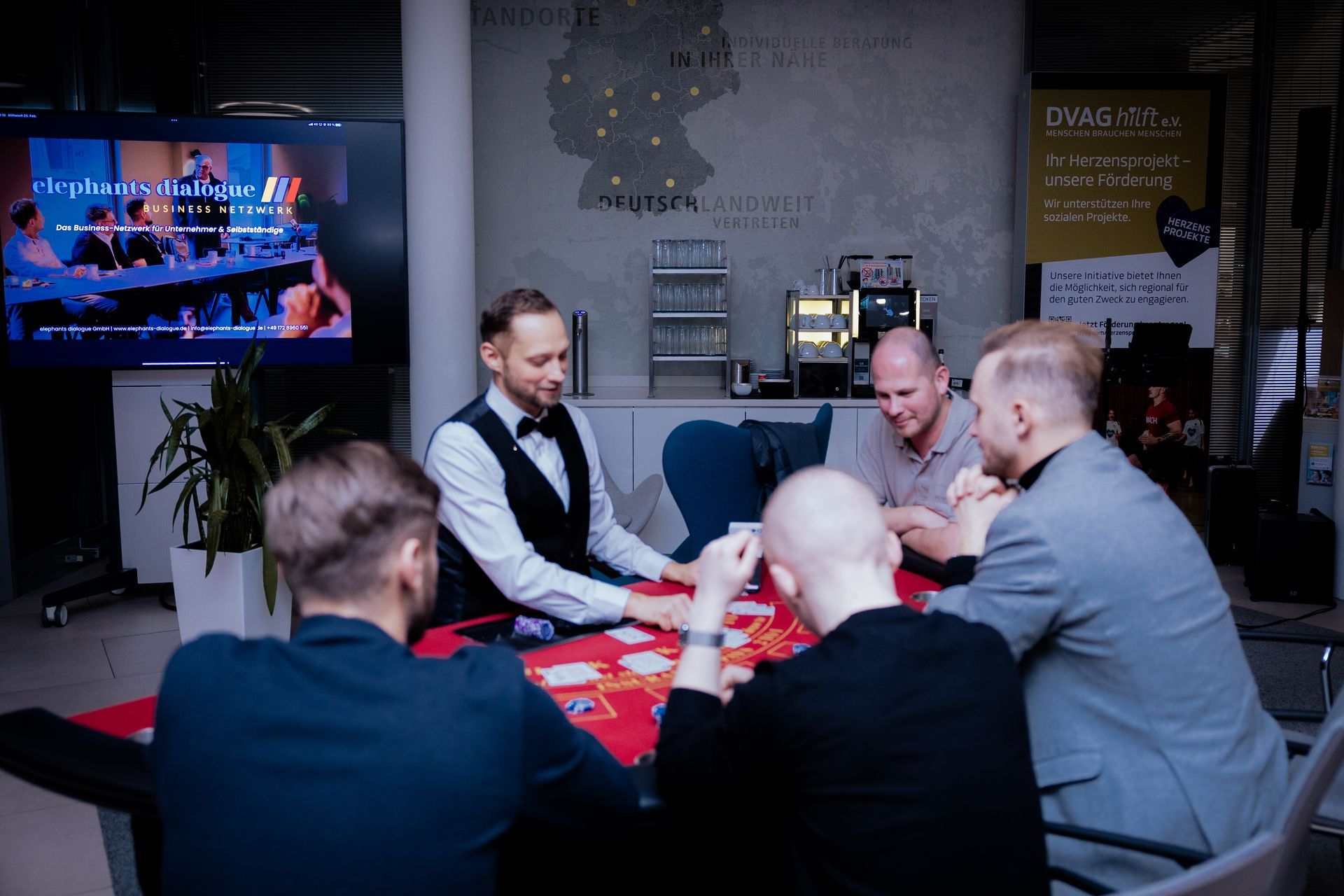 Ein Mann wird nachts in einem Veranstaltungsort interviewt und dabei von einer Person mit einer Kamera.