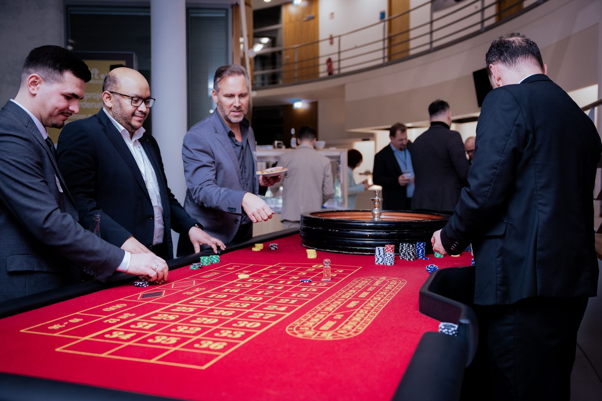 Zwei Männer, einer in einem roten, der andere in einem cremefarbenen Pullover, zeigen den Daumen nach oben. 