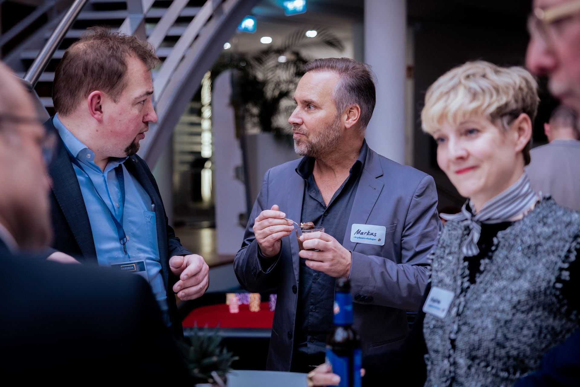Eine Frau schwingt einen Golfschläger auf einer nächtlichen Driving Range mit leuchtenden Zielscheiben.