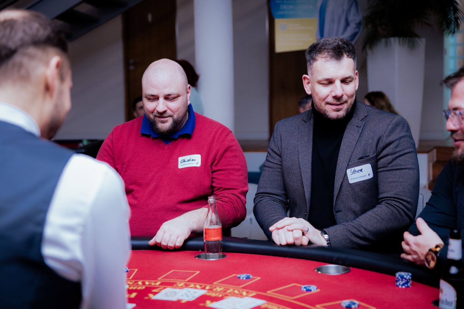 Eine Person, die nachts mit einem Golfschläger spielt, eine Weihnachtsmannmütze trägt und auf einer grünen Matte steht.