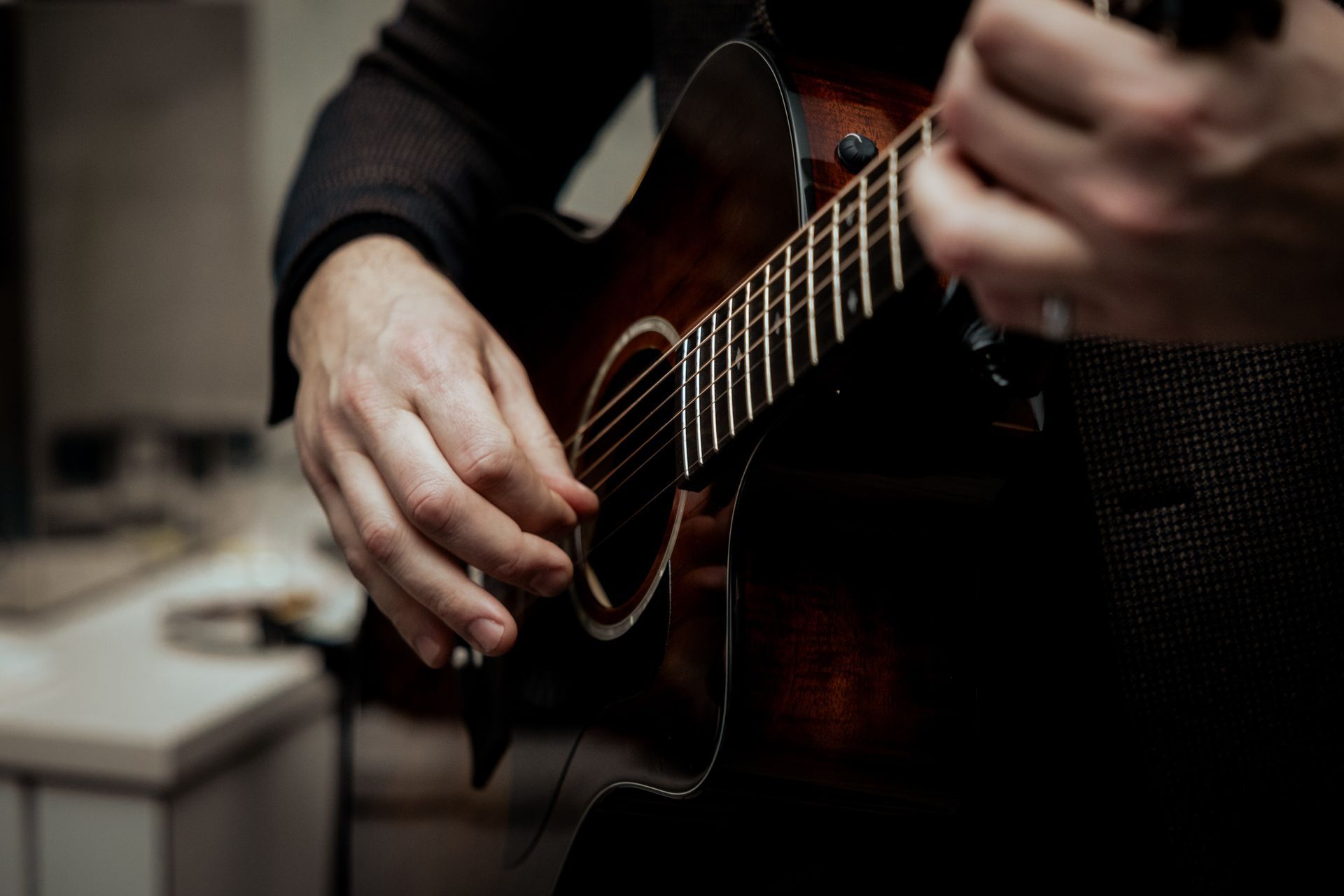 Eine Person, die auf einer nächtlichen Driving Range mit einem Golfschläger schwingt und einen blauen Hut mit Lichtern trägt.